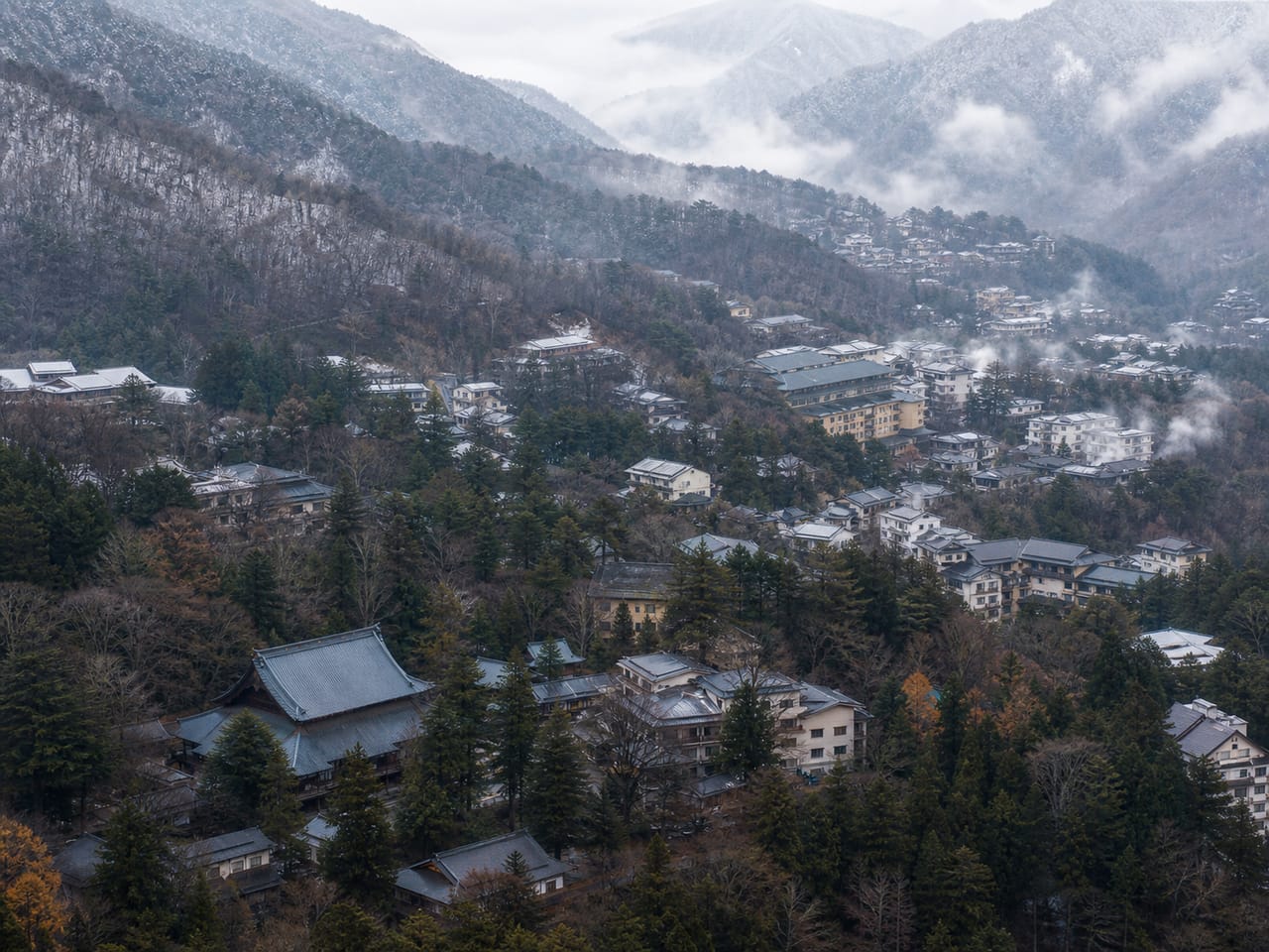 日光・那須・草津・伊香保の山岳エリア。古い温泉旅館と神社仏閣、山林が広がる俯瞰写真。