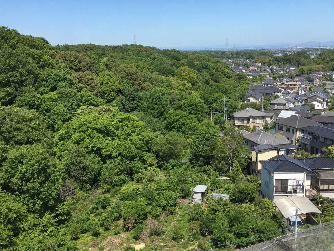 所沢・入間の狭山丘陵接続エリア。雑木林と住宅地の境界が連続する里山近接エリアの俯瞰写真。