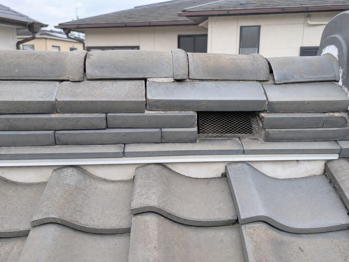 戸建て住宅の屋根まわり。瓦・換気口・雨どい・破風板を含む上部からの侵入経路を示す写真。
