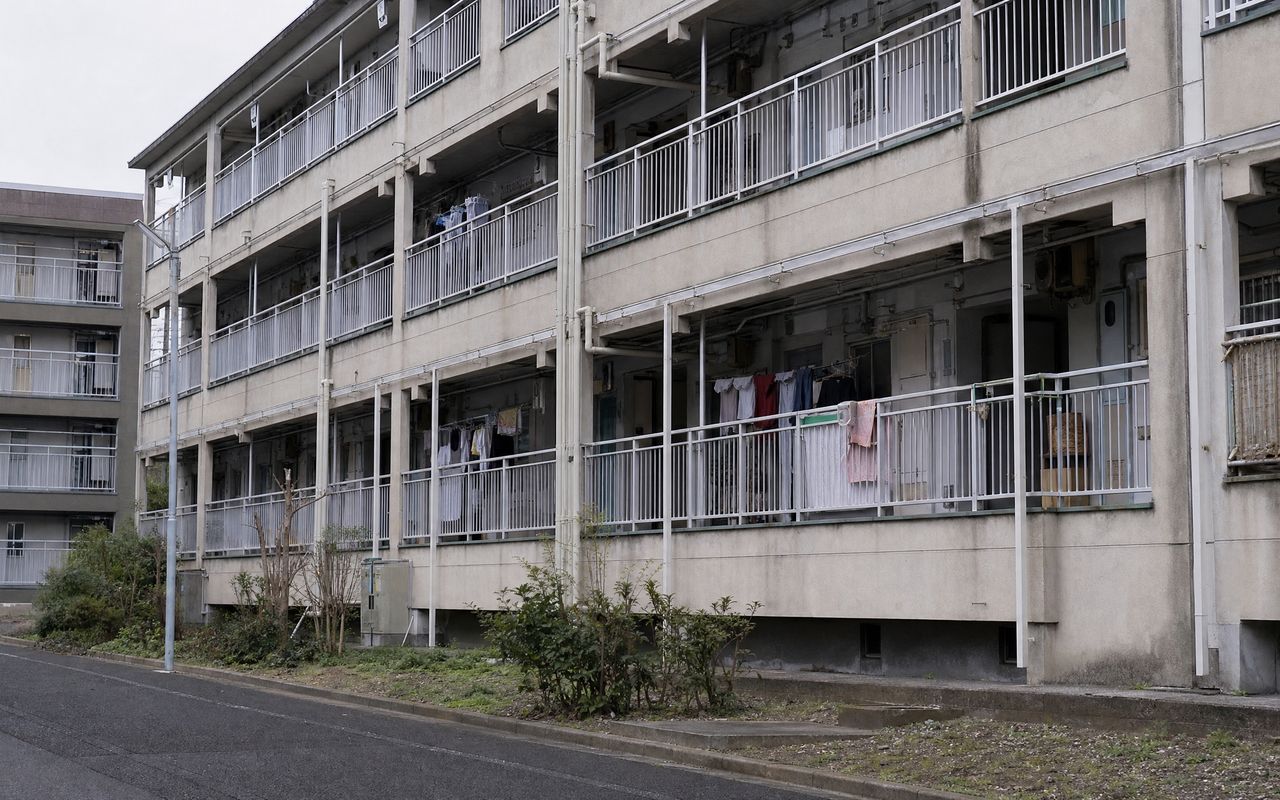 東京の築古RC集合住宅・公的住宅。共用廊下と配管・パイプスペースが見える外観写真。