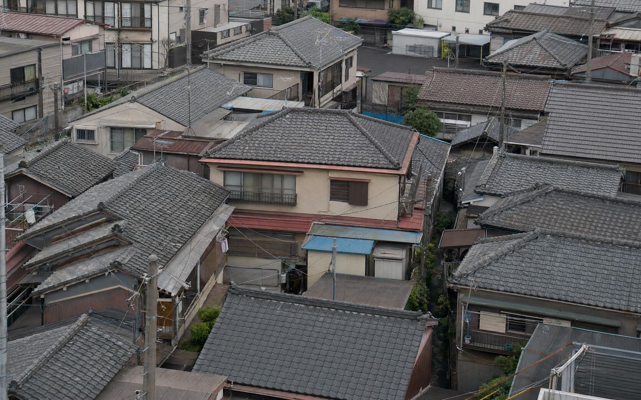 東京の木造住宅密集地域。隣家との隙間が狭く屋根が連なる戸建てエリアを俯瞰した写真。