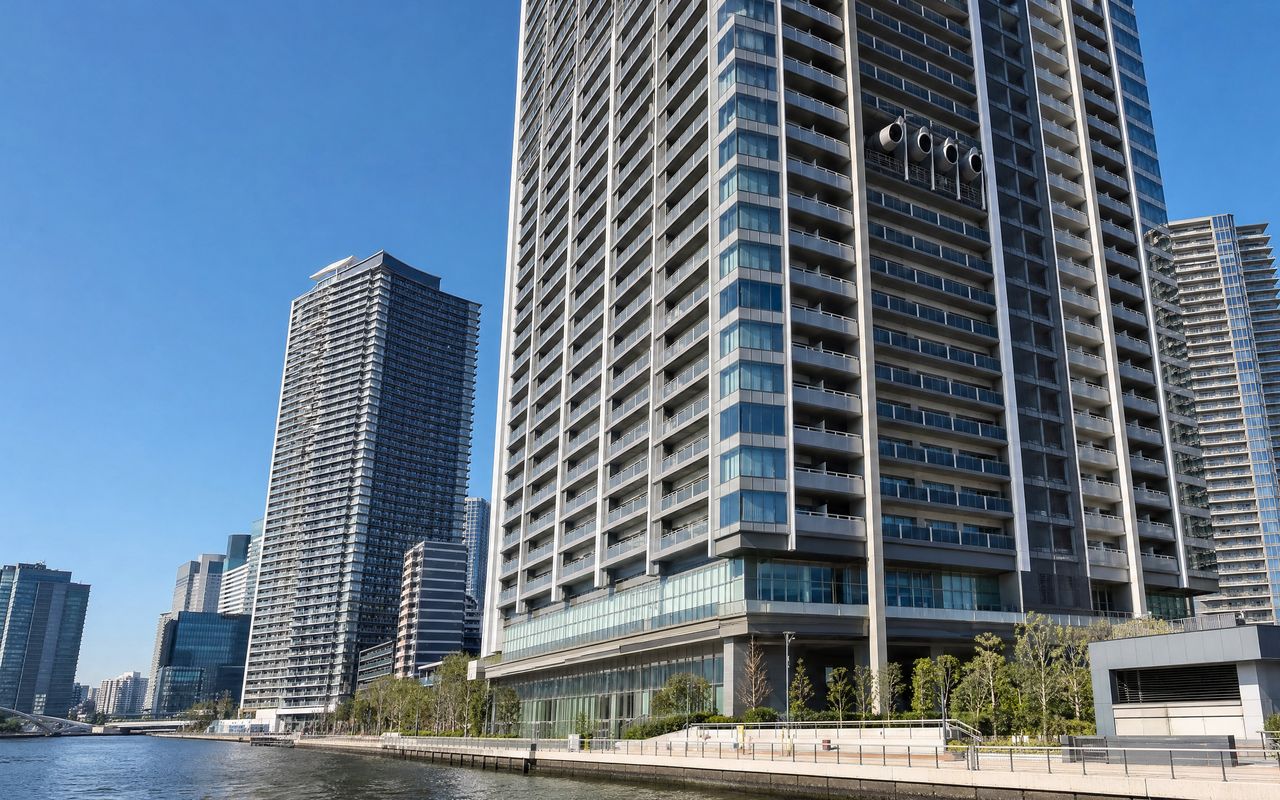 東京湾岸エリアの高層タワーマンション群。上層階の通気孔や換気ダクトが見える外観写真。